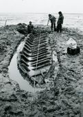 Scheepsopgraving op het verdronken land van Zuid-Beveland. In 1982 werd op de slikken van Krabbendijke bij het verdronken dorp Nieuwlande een platboomd vaartuig vrij gelegd. Het dateert uit het begin van de zestiende  eeuw. Liggers of kespen houden de vlakplanken bijeen, terwijl zij worden afgewisseld door spanten die uit twee op elkaar aansluitende knieën zijn opgebouwd.