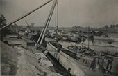 Verwoesting in de haven van Maasbracht, 1944. De haven van Maasbracht ligt bijna droog. Dit biedt een goede mogelijkheid om de schade op te nemen en zoveel mogelijk schepen provisorisch te herstellen