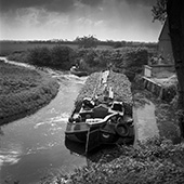 Start van de suikerbietencampagne, 1951. De reis van schipper S. Meter van de </em>Twee gezusters</em> (40 ton) met de eerste suikerbieten van het seizoen vanuit Friesland naar de suikerfabriek in Groningen begon niet fortuinlijk. Zijn kleine volgeladen vaartuig kon slechts met de grootste moeite door een smalle, ondiepe, slecht onderhouden bocht komen. Zijn schip werd voortgetrokken door een opduwer, die in dit geval dienst deed als sleepbootje. Twintig jaar later was dit vervoer overgenomen door vrachtauto’s.