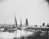 Merwedekanaal, 1897. Drie zeilschepen passeren een opengedraaide draaibrug, de latere Muntbrug in Utrecht, op het drukbevaren Merwedekanaal. De brug werd in 1887 bij de aanleg van het kanaal gebouwd en is thans een rijksmonument.