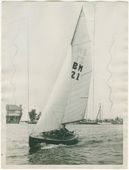 BMer nr. 21. De BMer met nummer 21 zeilt voor de fotograaf langs tijdens de eerste Nationale Zeilwedstrijd van de watersportvereniging ‘De Schinkel’ op de Nieuwe Meer, 1932. Op de afdruk zijn markeringen aangebracht; vermoedelijk om aan te geven in welke uitsnede de foto gepubliceerd diende te worden in de <em>Waterkampioen</em>.